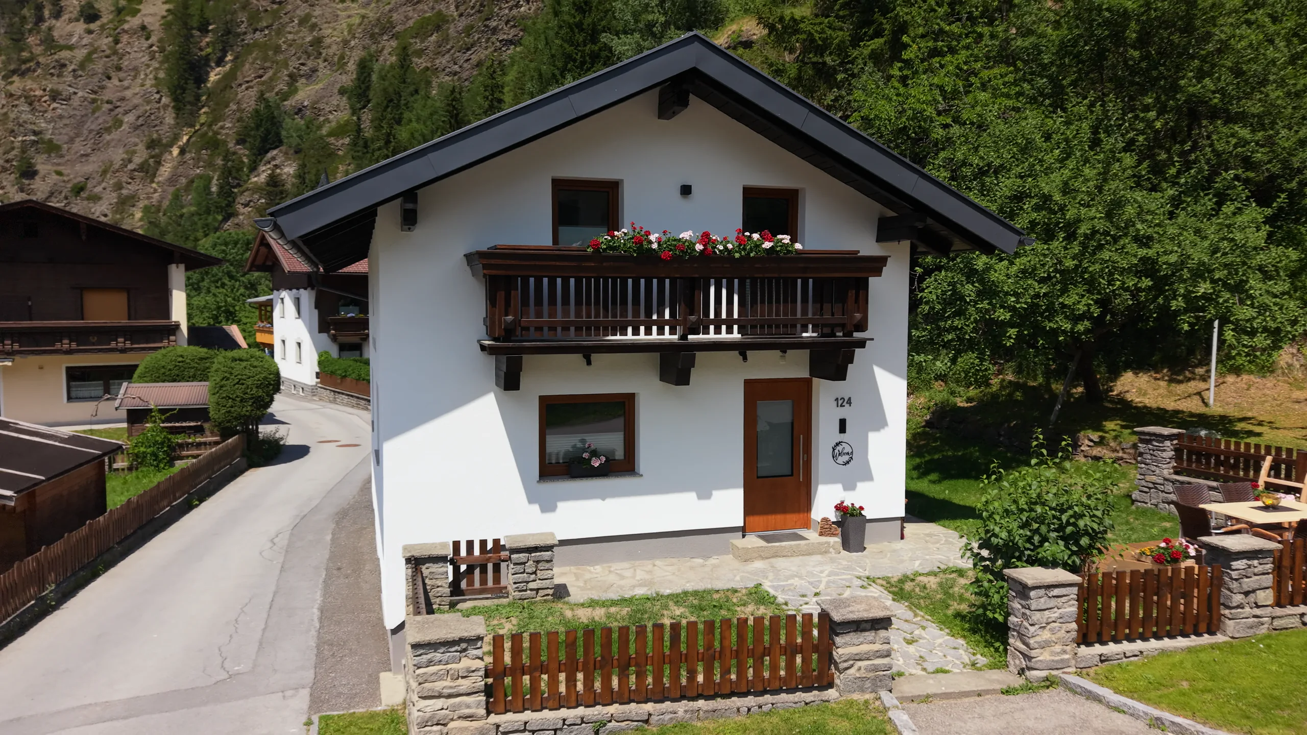 Direkt vor Irmas Ferienhäusl: Balkon mit Geranien, Hausnummer 124 und die Haustür