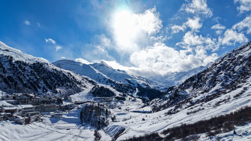 Wintersonne über einem tief verschneiten Bergdorf