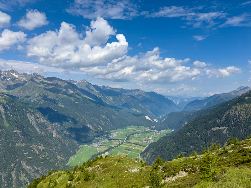 Blick vom Berg über das weite Tal mit Dörfern und Feldern